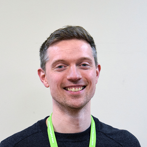 Jamie Robertson, Voice and Advocacy Manager, smiling in front of a white background.