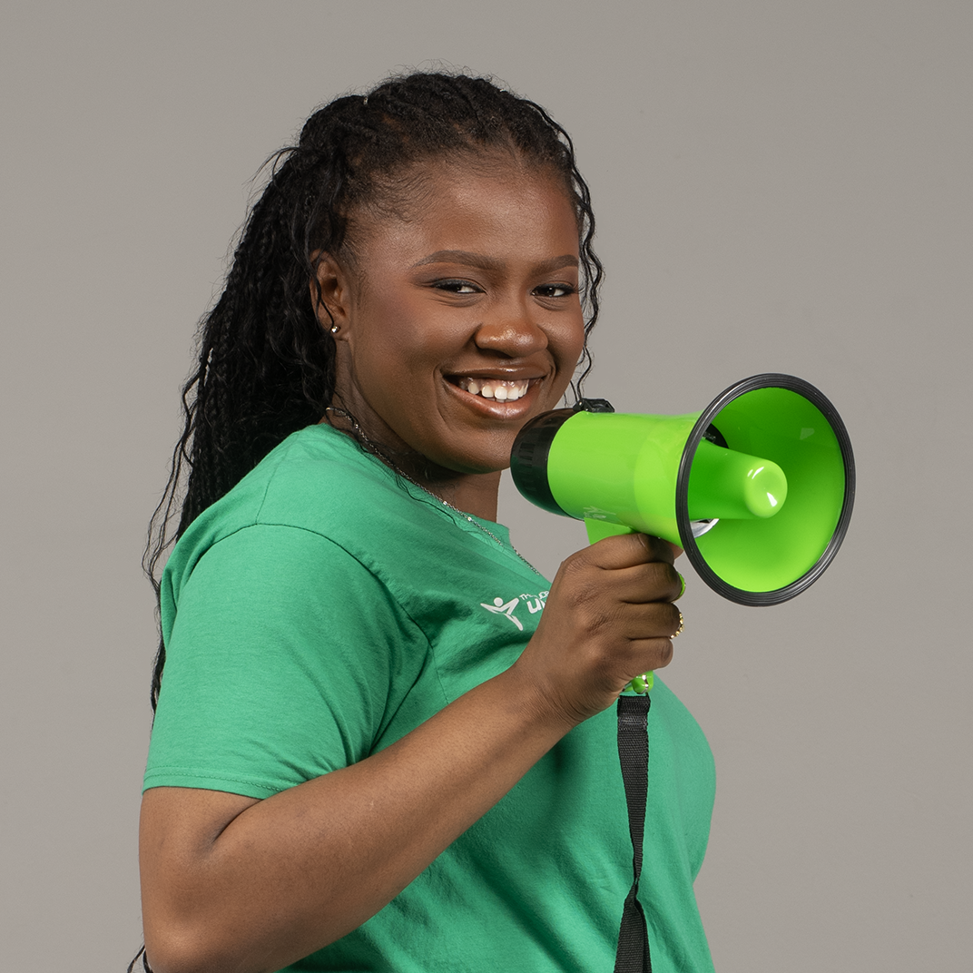 Precious Ogbein smiling brightly, wearing a green Union shirt and holding a megaphone.